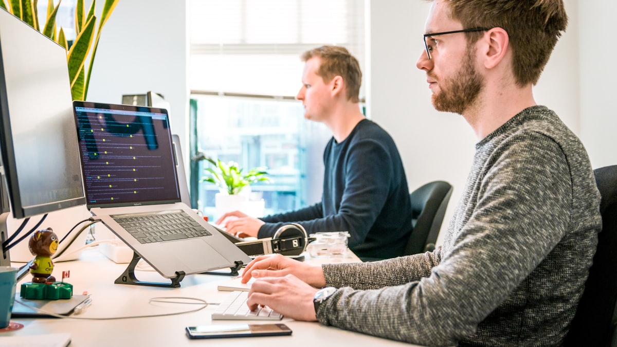 Two colleagues working at adjacent desks